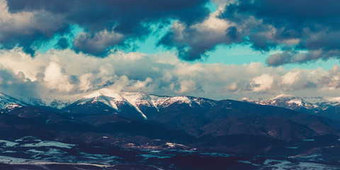 Fototapeta na wymiar Photo depicting a beautiful moody frosty landscape European alpine mountains with snow peaks on a blue sky background.