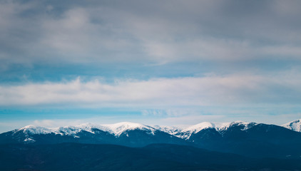 Fototapeta na wymiar Photo depicting a beautiful moody frosty landscape European alpine mountains with snow peaks on a blue sky background.