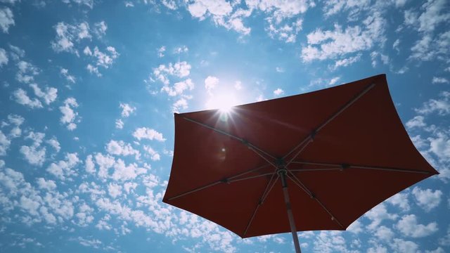 Holiday at sea, view of the beach umbrella and sky from the first person.
