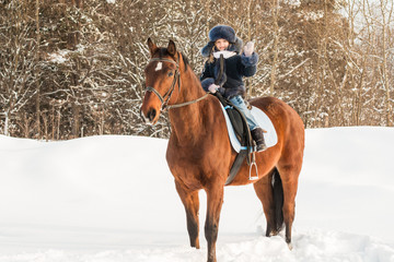 Small girl and horse in a winter