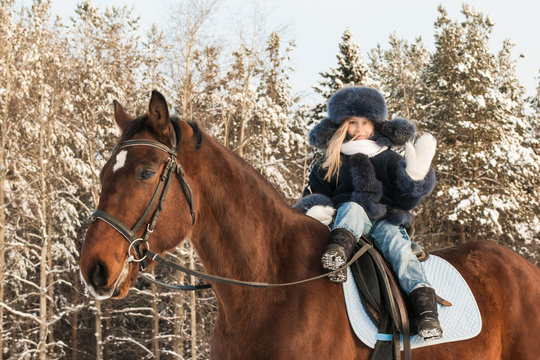 Small girl and horse in a winter