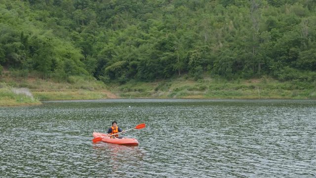 4k video of Young man kayaking on the river and mountain in Kanchanaburi, Thailand