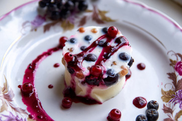 Cool jelly dessert with fresh berries on a light plate close up. side view