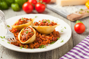 Italian pasta Conchiglioni Rigati stuffed with dry tomatoes and meat.