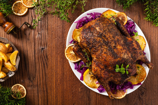 Baked whole duck, served with apples, red cabbage, oranges and roasted fritters.