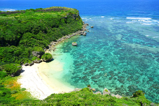 Landscape view of the Happy Cliff (Kafu Banta) overlooking the azure sea and a golden beach in Uruma, Okinawa, Japan