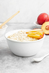 Oatmeal with nectarine and honey on a gray background
