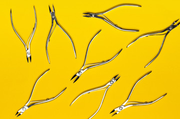 Tools of a manicure scissors on a yellow background