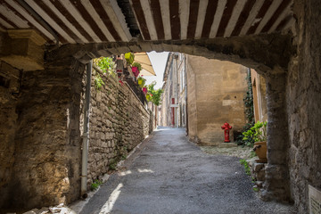 Narrow street with ancient houses at beautiful little village Bonnieux in Provence, France