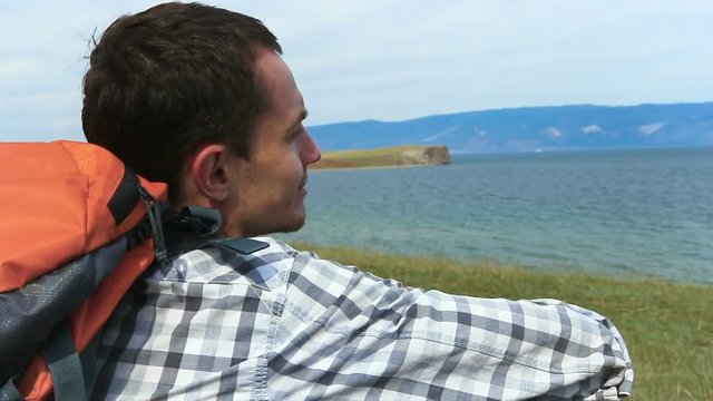 Traveler young Man resting with serene view of lake Baikal. landscape Travel Lifestyle hiking concept summer vacations outdoor