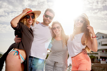 Friends posing at beach, sea in background