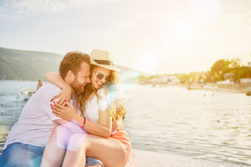 Fototapeta premium Young Caucasian couple enjoying sunset at beach