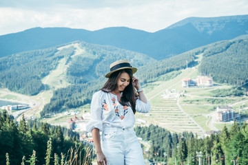 Naklejka premium young pretty woman walking by mountain peak