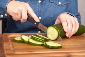 woman cutting a cucumber
