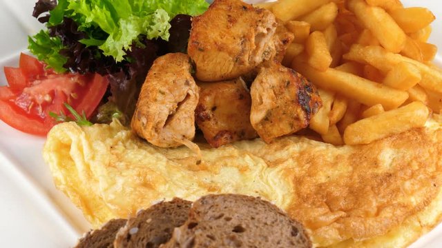 Plate of breakfast, Omelette with chicken kebab, french fries and vegetables, loop, 4K, ProRes codec, 422 HQ, ISO 100