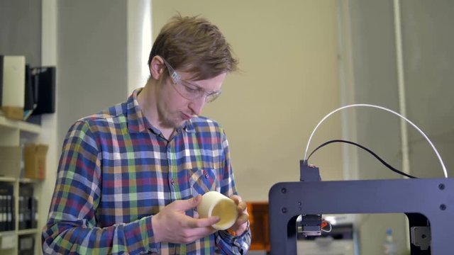 A man takes a finished 3d-printed sample. 