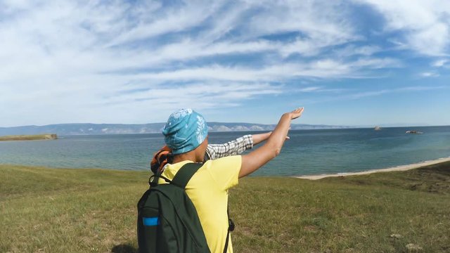 Hiking Couple Exploring Olkhon island in beautiful blue lake Baikal. Travel nature footage man woman enjoying adventurous vacation beauty backpacker tourist. Olkhon Island, Baikal, Russia, Siberia