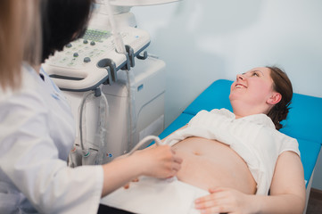 young pregnant woman on the ultrasound, health check with the doctor