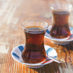 Black herbal turkish tea in traditional glass at the street cafe