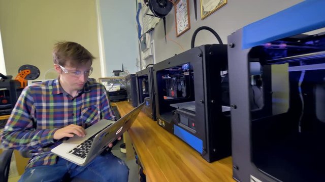 A long row of 3d-printers for an engineer to control. 