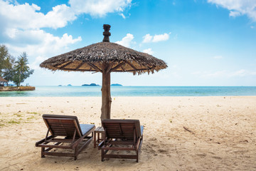Two lounge chairs and a sunshade umbrella on the beach