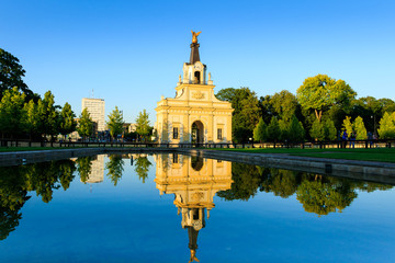 Reflection in water of the historic entrance gate of the baroque Branicki Palace in setting sun, Białystok, Poland