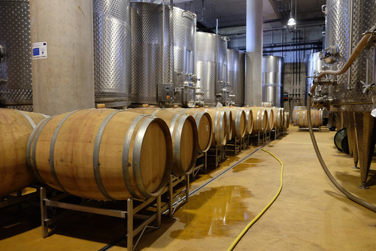Modern winery with aluminium tanks and wine barrels