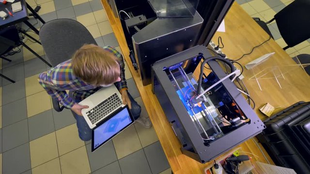 A man oversees several 3d-printing projects at once. 