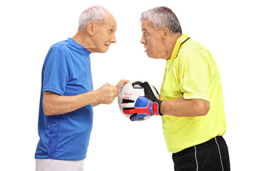 Elderly soccer player and a goalkeeper having an argument