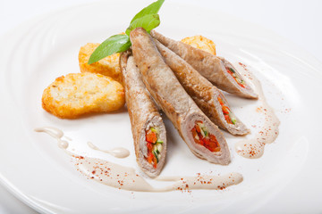 Chicken roll with vegetables on a white table