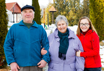 Elderly couple and young caregiver