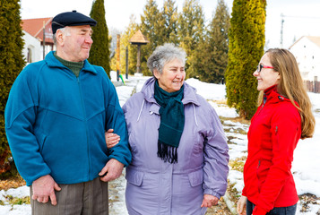 Elderly couple and young caregiver