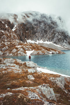 Person on rocky shore in mountains