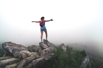 girl traveler with a camera in mountains