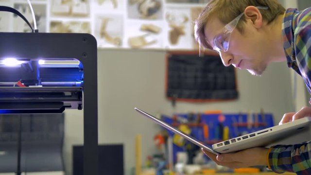 An engineer corrects 3d-printing process. 