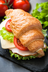 Croissant sandwich with ham, cheese, lettuce and tomato