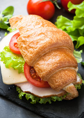Croissant sandwich with ham, cheese, lettuce and tomato