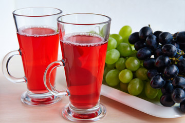 Two glasses of juice and black grapes