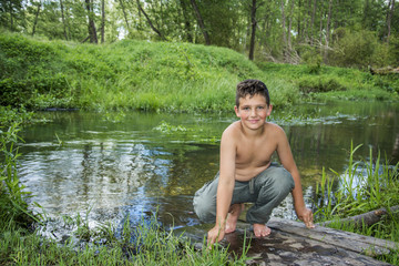 In summer there is a boy on the river bank.