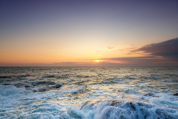 Tropical colorful sunset at the stones beach