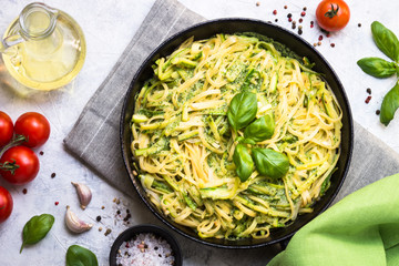 Pasta spaghetti with zucchini basil and cheese.