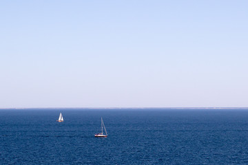 Obraz premium Two sailboats on a blue sea