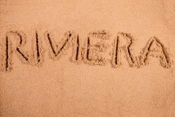 Riviera written in soft wet sand on a beach
