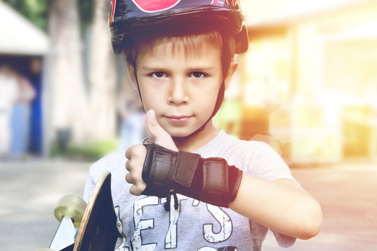 Boy with skateboard showing thumbs up