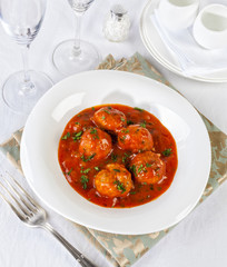 Tasty meatballs in tomato sauce with parsley.