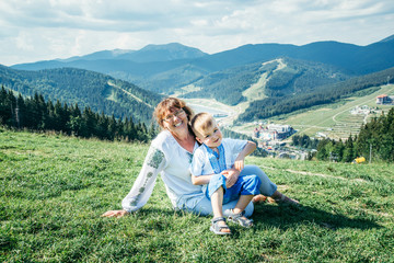 Fototapeta premium grandmother with kid on the peak of the mountains
