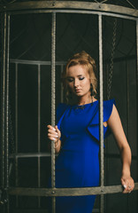Портрет красивой девушки в вечернем синем платье в интерьерной студии 