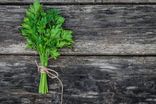 a bunch of parsley on wooden background