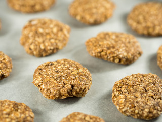 Table with raw oat cookies over baking paper