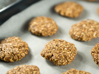 Table with raw oat cookies over baking paper